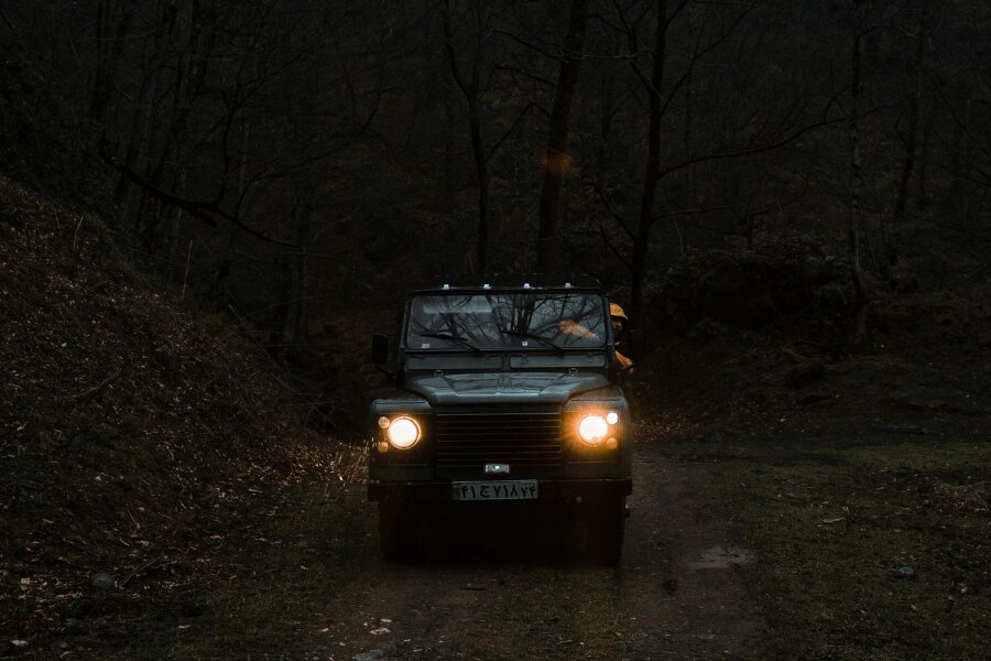 Jízda terénním vozidlem v noci na lesní cestě, což představuje zvýšené riziko střetu se zvěří. Foto: https://images.pexels.com/photos/9245646/pexels-photo-9245646.jpeg?_gl=1*4ll9eu*_ga*MTYyMTU5NDI2NS4xNzUwNzYzNDA4*_ga_8JE65Q40S6*czE3NTk0OTQ1NTckbzE1JGcxJHQxNzU5NDk0NjM3JGo0NCRsMCRoMA..