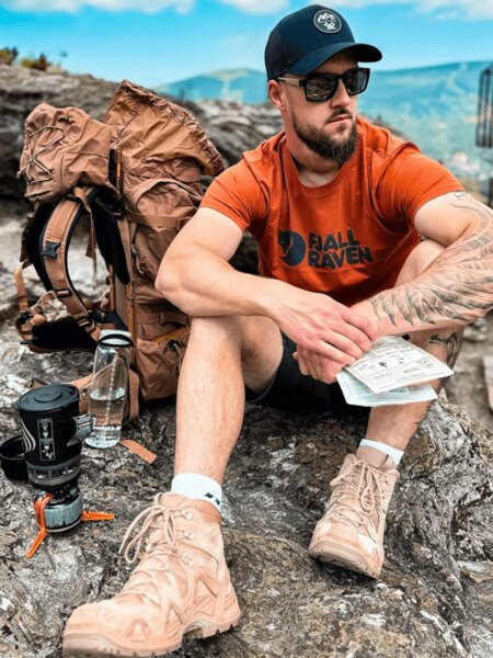 Outdoorový turista s batohem, kšiltovkou a vodou jako ochrana před úpalem. Foto: Rigad
