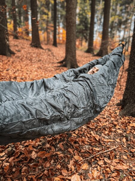 Hamaka s kokonovým spacákem Cocoon zavěšená mezi stromy, izolace pro spaní v chladných podmínkách v přírodě. Foto: Rigad