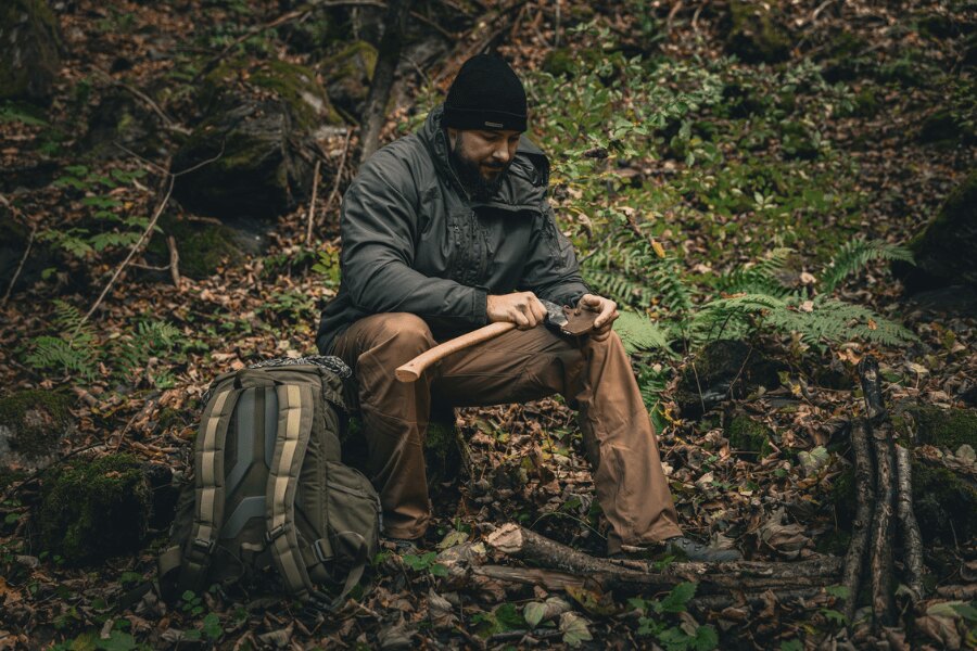 Zimní bunda Helikon-Tex Yukon při práci v táboře – odolná proti jiskrám a mechanickému opotřebení.