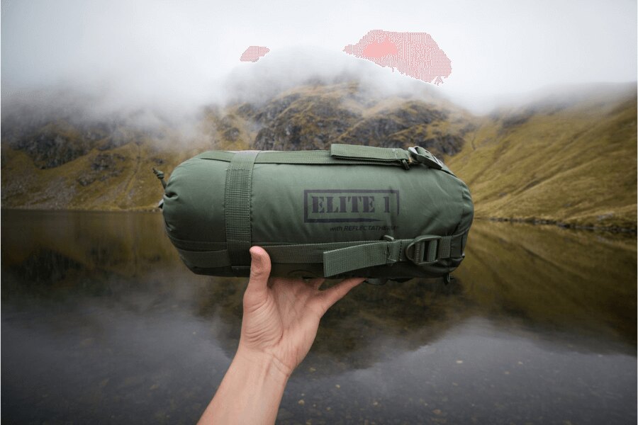 Sbalený spacák v kompresním obalu před horským jezerem, připravený na podzimní trek. Foto: Rigad