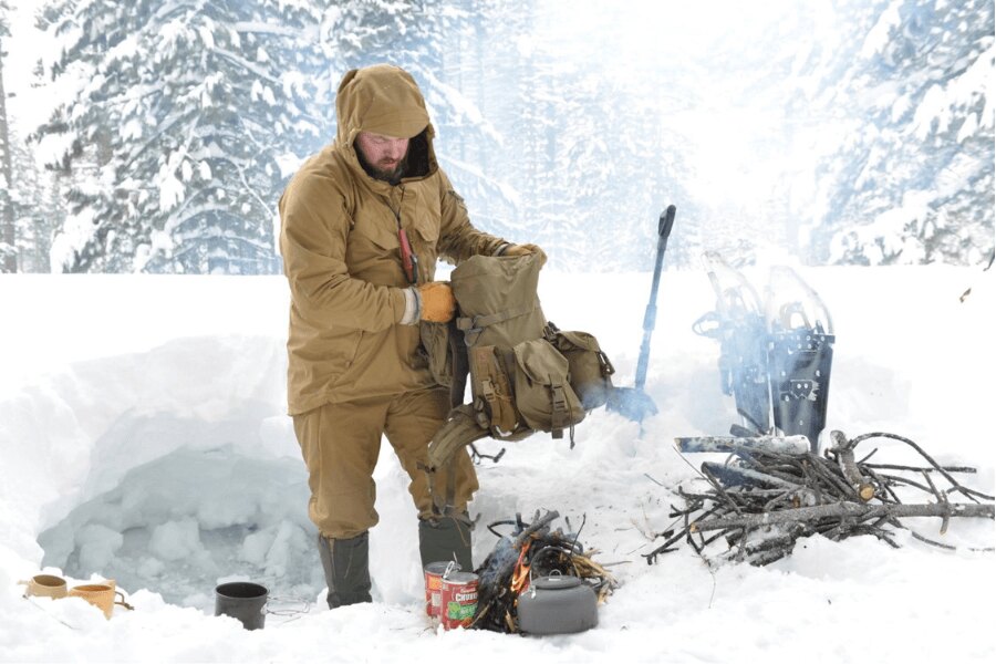Příprava výbavy a teplého zázemí při zimním nocování na sněhu před setměním. Foto: Helikon-Tex, Rigad