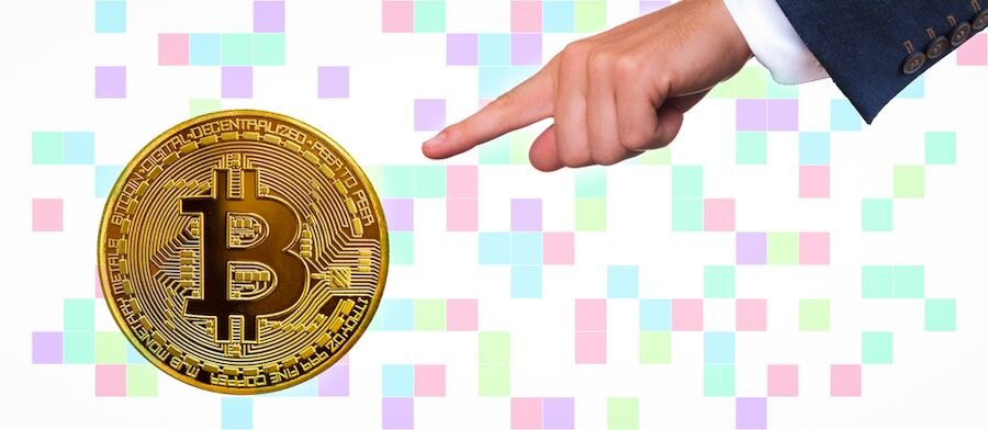 Ruka ukazující na bitcoin