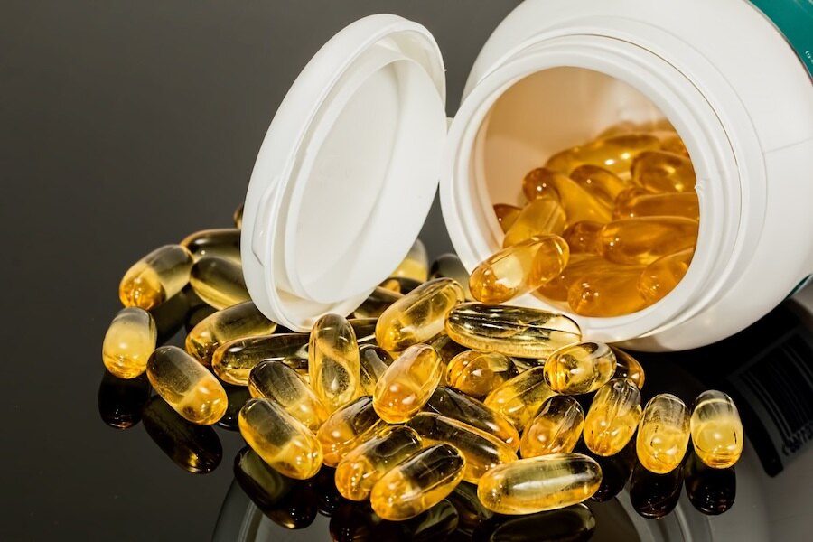Vysypané kapsle vitamínu na stole